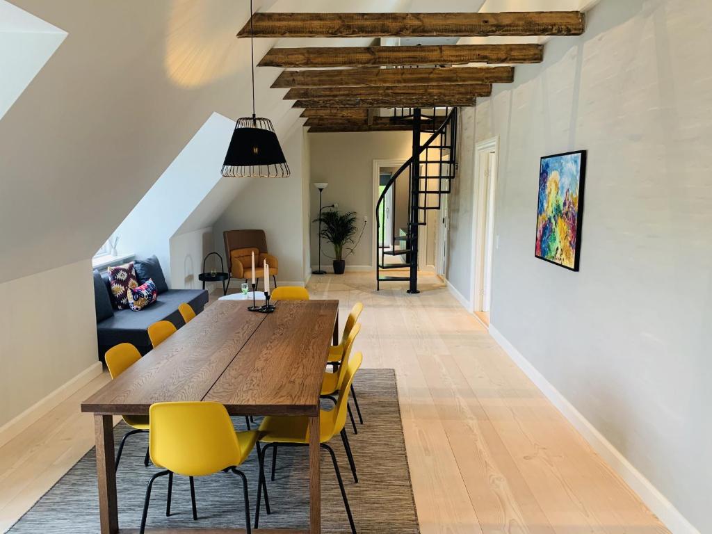 奥尔堡aday - 3 bedroom - Modern Living Apartment - Aalborg Center的一间带木桌和黄色椅子的用餐室