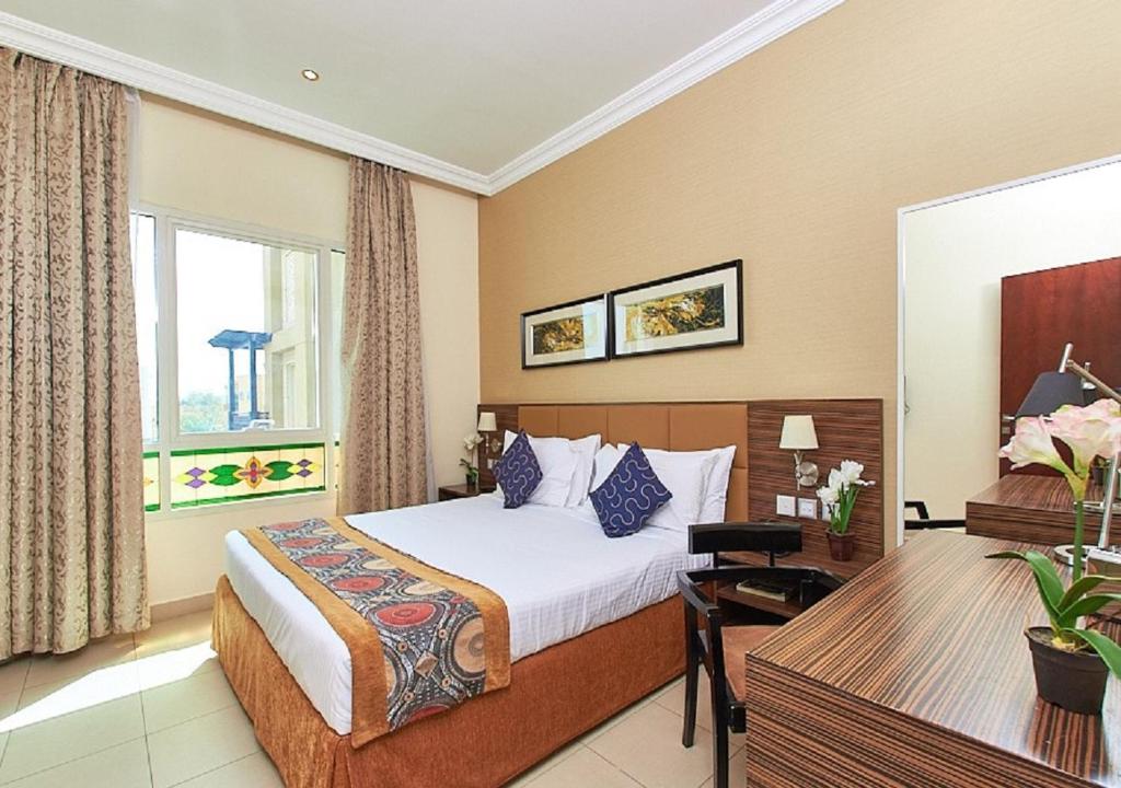 拉斯阿尔卡麦Mughal Suites的配有一张床和一张书桌的酒店客房