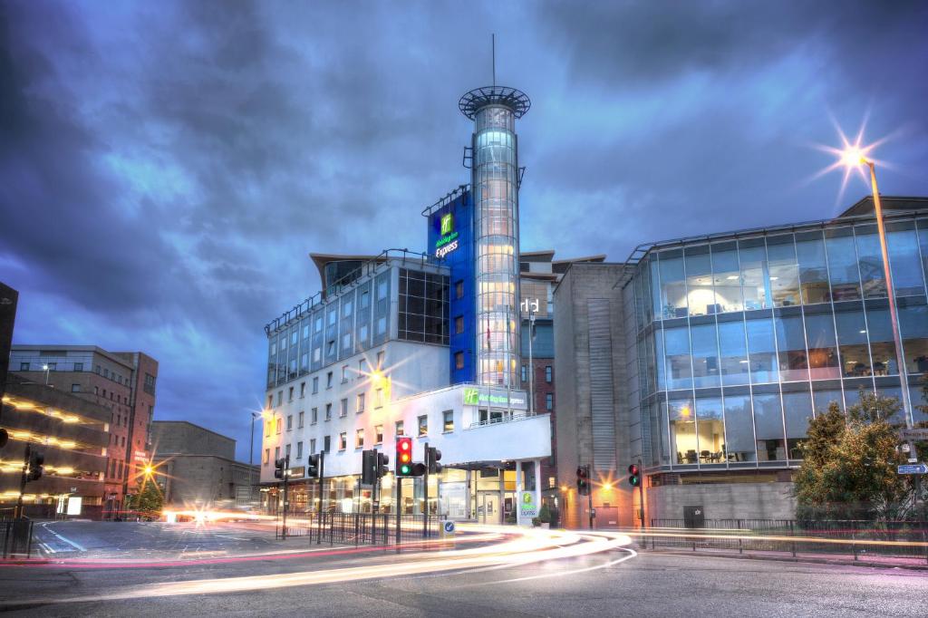 格拉斯哥快捷假日格拉斯哥剧院区酒店的一座建筑,上面有一座塔,晚上