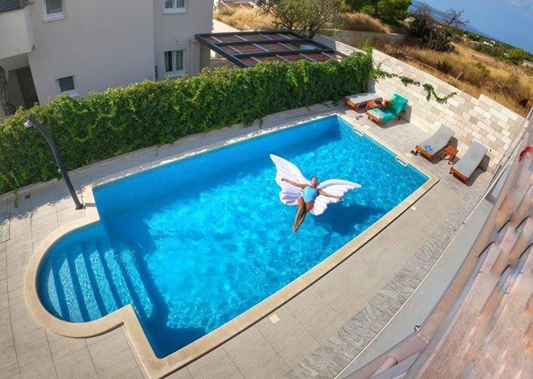 波尔Villa Amorena - Adults Only的游泳池的顶部景色,上面有蝴蝶