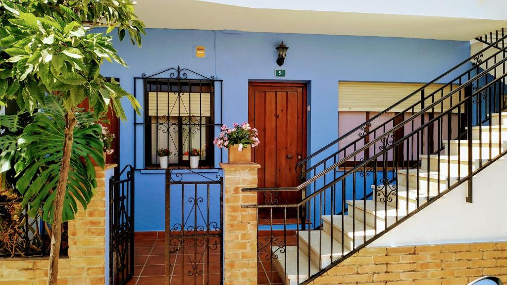 福恩吉罗拉Apartamento Fuengirola Centro的蓝色的房子,有楼梯和门