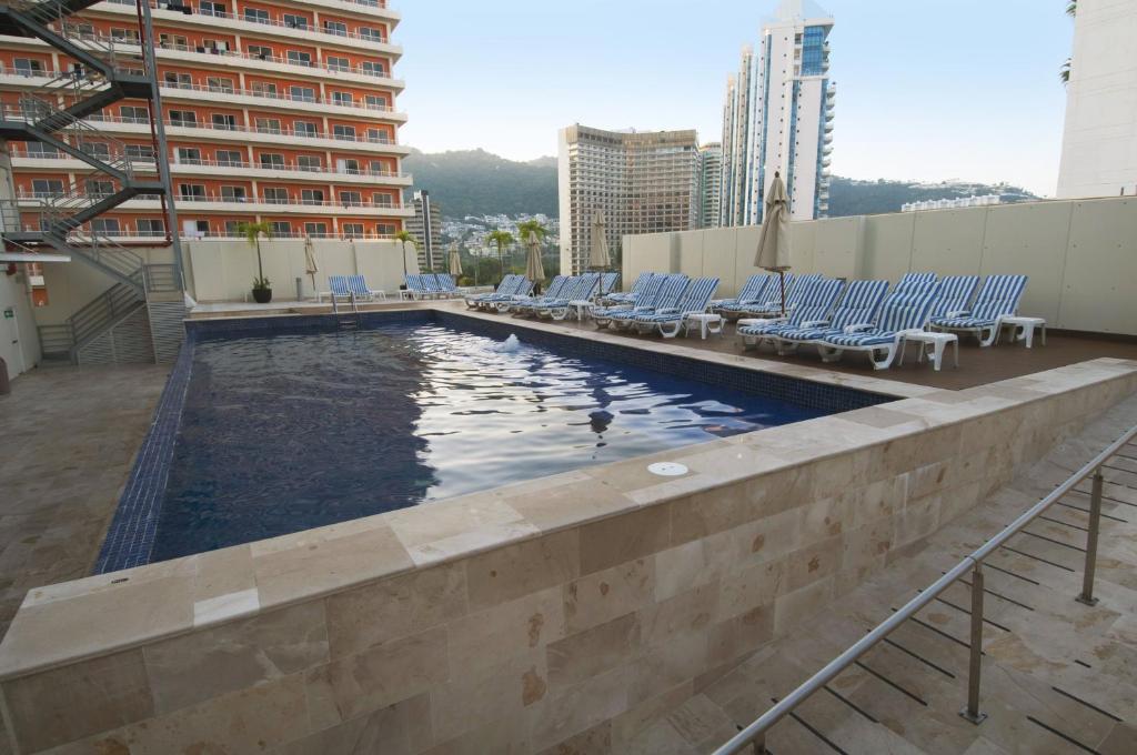 阿卡普尔科阿卡普尔科海岸酒店的一座带椅子的建筑屋顶上的游泳池
