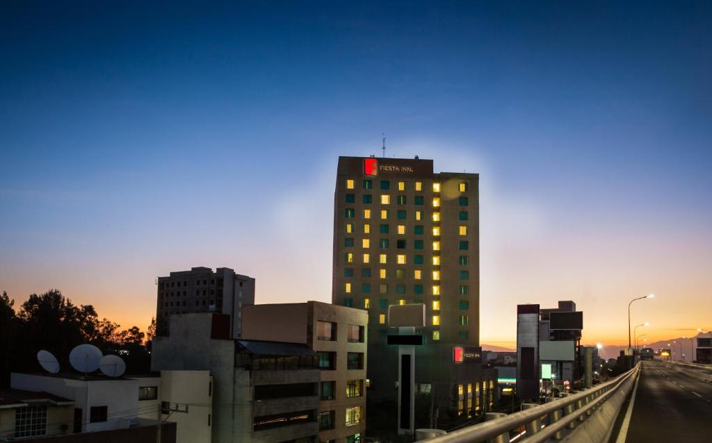 墨西哥城佩里费里克南费斯塔酒店 的落日时城市的高楼