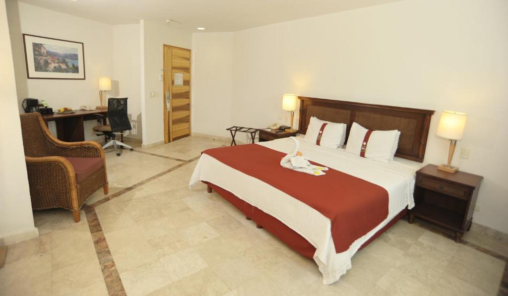 伊斯塔帕Gamma Plaza Ixtapa的一间卧室配有一张大床和一张书桌