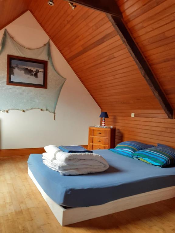 Quemper-GuézennecGite kerblouc'h的一间卧室设有一张床和木制天花板