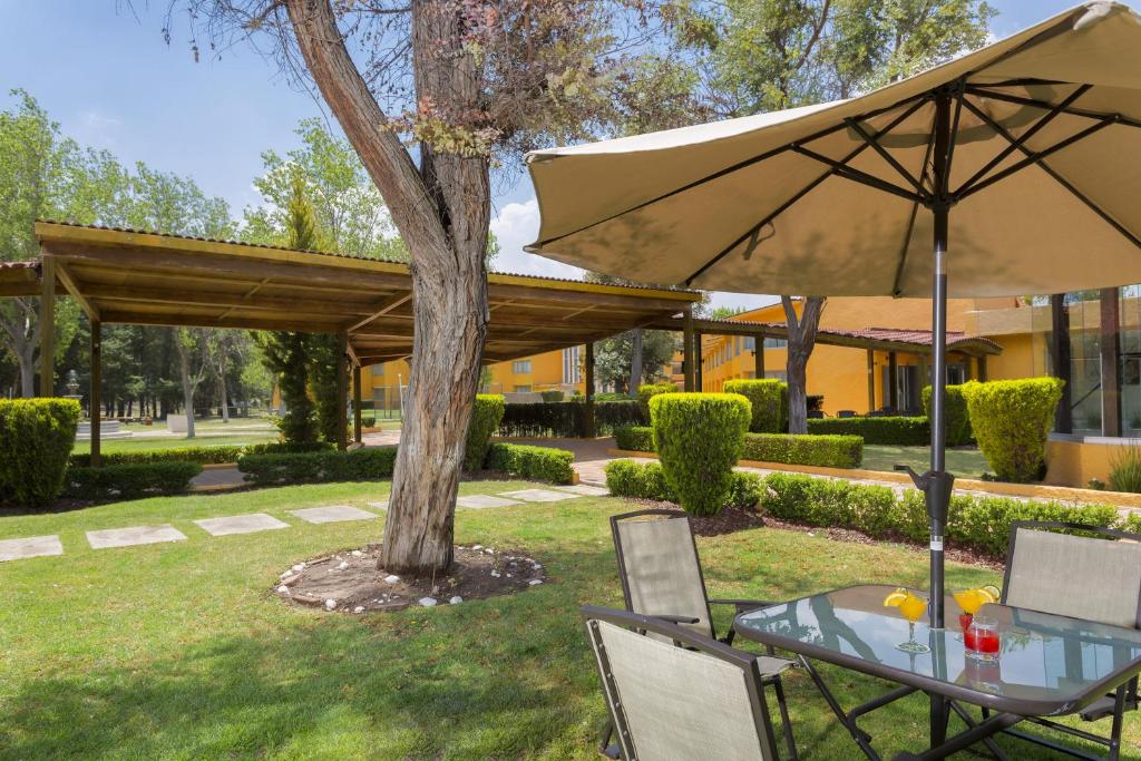 帕丘卡德索托伽玛帕丘卡酒店的院子里的桌椅和雨伞