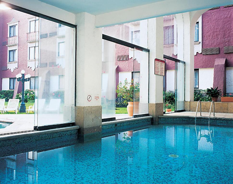 贾拉普哈拉帕嘉年华酒店的一座带窗户的建筑中央的游泳池