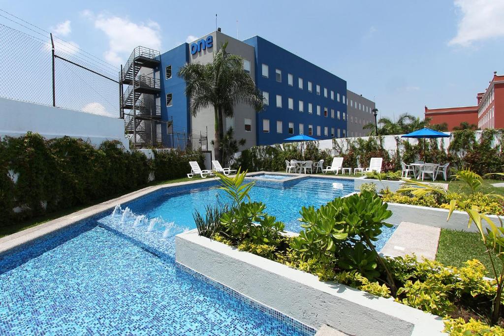 库埃纳瓦卡库埃纳瓦卡酒店的一座大楼前的游泳池,带喷泉