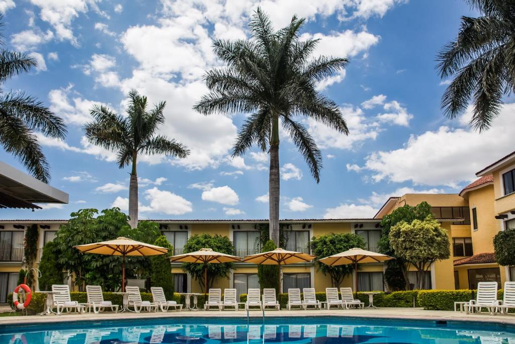 瓦哈卡市瓦哈卡嘉年华酒店的拥有游泳池和棕榈树的酒店