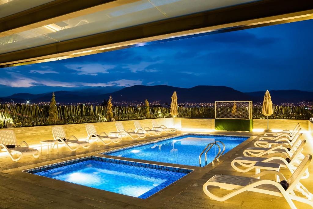 帕丘卡德索托帕丘卡大庭院嘉年华酒店的一个带躺椅的游泳池和一个泳池景