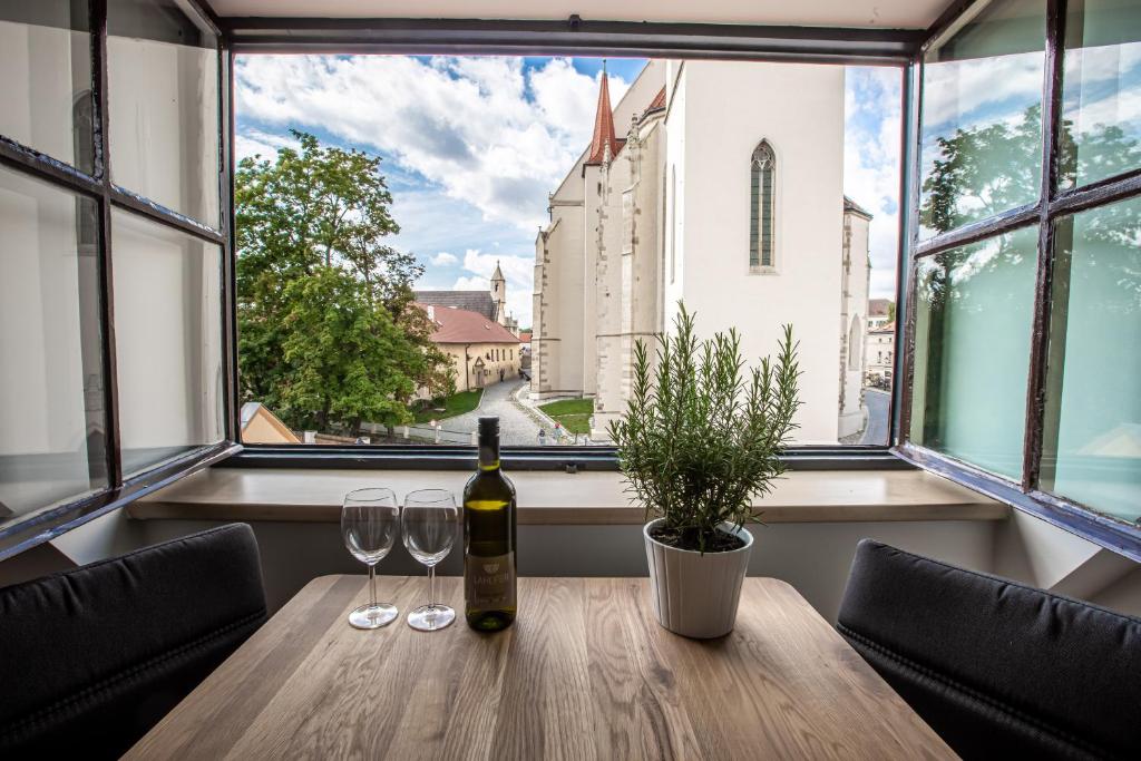 兹诺伊莫Apartmány na Mikulášském náměstí的一张桌子,上面放着一瓶葡萄酒和两杯酒