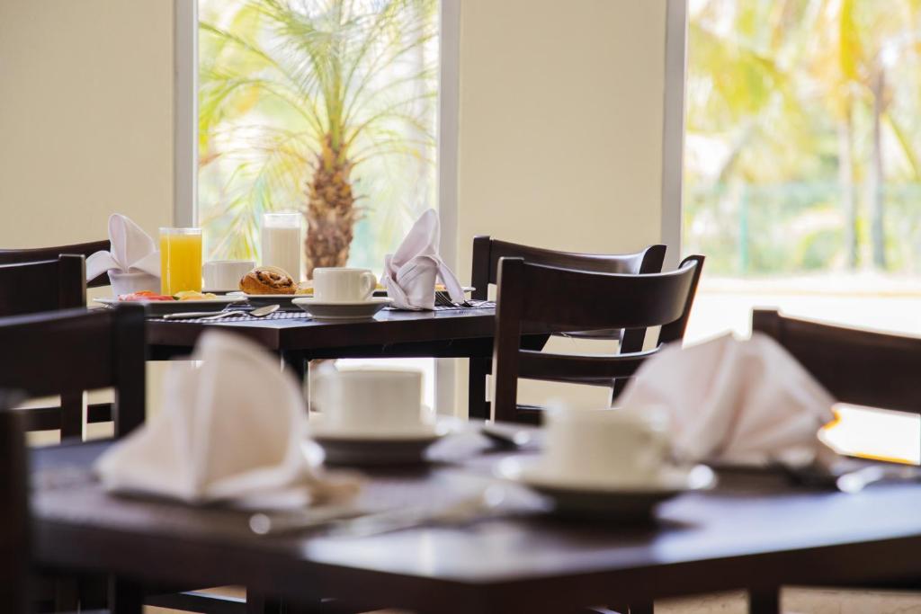 坦皮科Gamma Tampico的用餐室配有桌椅、杯子和餐巾