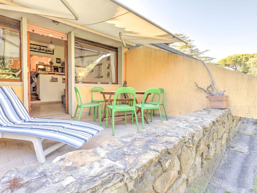 蓬塔阿拉Belvilla by OYO Le Mimose nr 12的石头墙上的庭院配有椅子和桌子