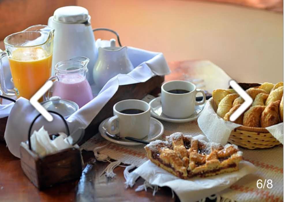 阿祖尔海森林露营地山林小屋的一张桌子,早餐包括咖啡、糕点和橙汁