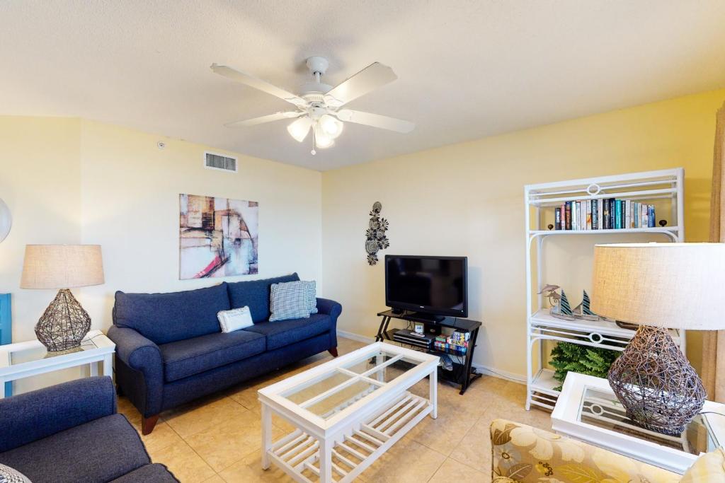 沃尔顿堡滩Islander Condominiums III的客厅配有蓝色的沙发和电视