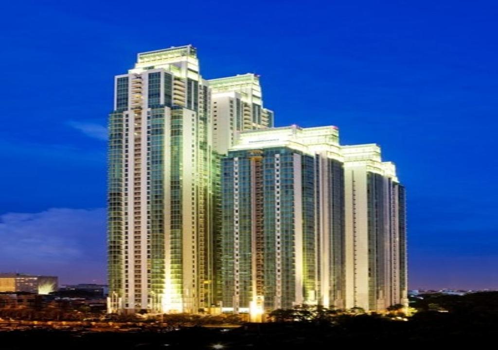 雅加达雅加达苏迪曼辉盛庭国际公寓的一座高大的建筑,晚上有灯