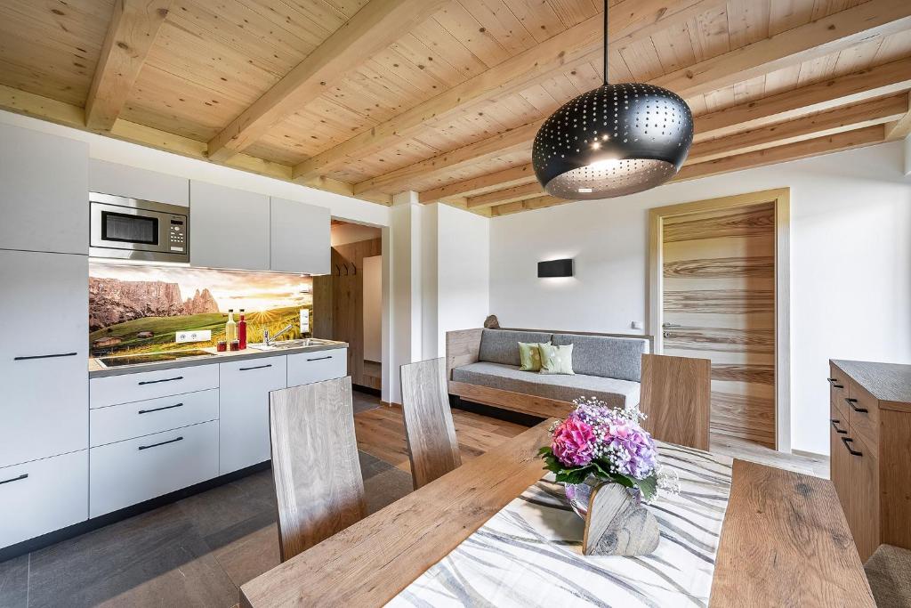 菲耶Foreserhof的一间厨房和带木制天花板的用餐室