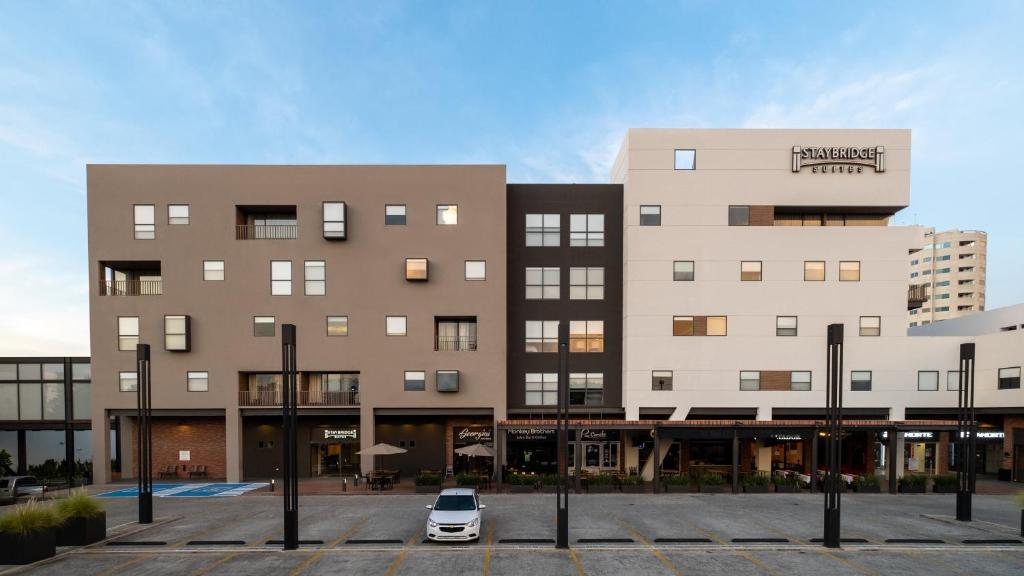 比亚埃尔莫萨Staybridge Suites - Villahermosa Tabasco, an IHG Hotel的停在大楼前停车场的汽车