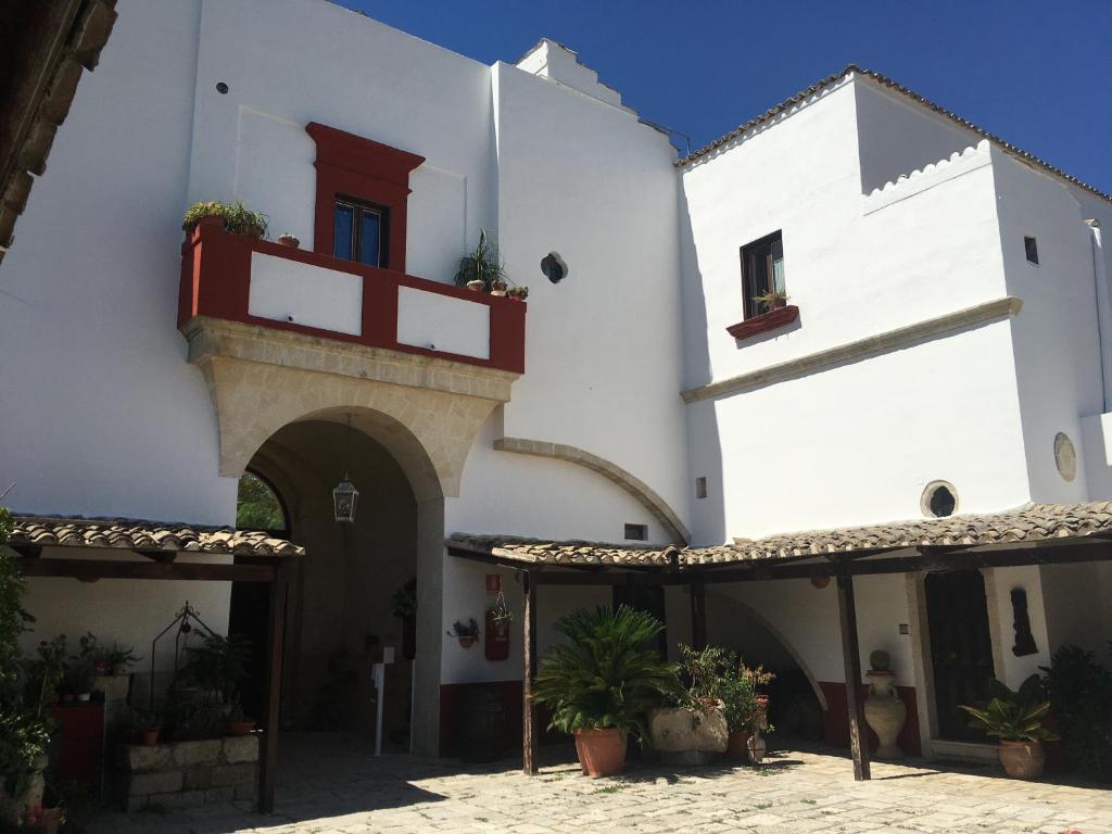 蒙泰斯卡廖索Oasi Rupestre的白色的建筑,设有红色的门和阳台