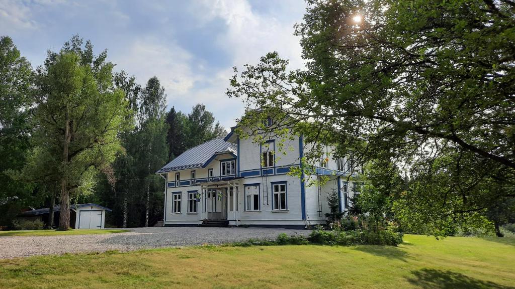 哈格福什Geijersholms Herrgård的一座蓝色和白色的大房子,有院子