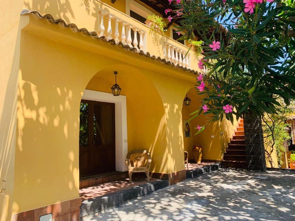 莫塔卡玛斯特拉Villa Le Gemelle Dell'Alcantara的黄色的房子,有楼梯通往前门