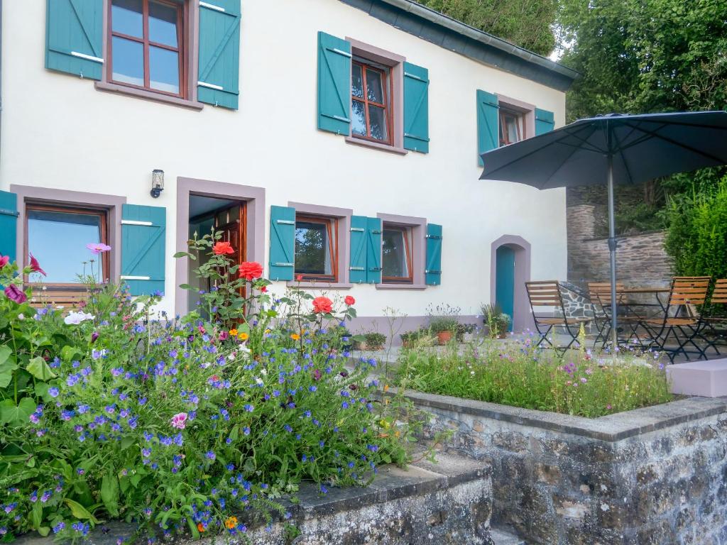 萨尔堡Das Kartenhaus的一座拥有五颜六色的鲜花和遮阳伞的房子