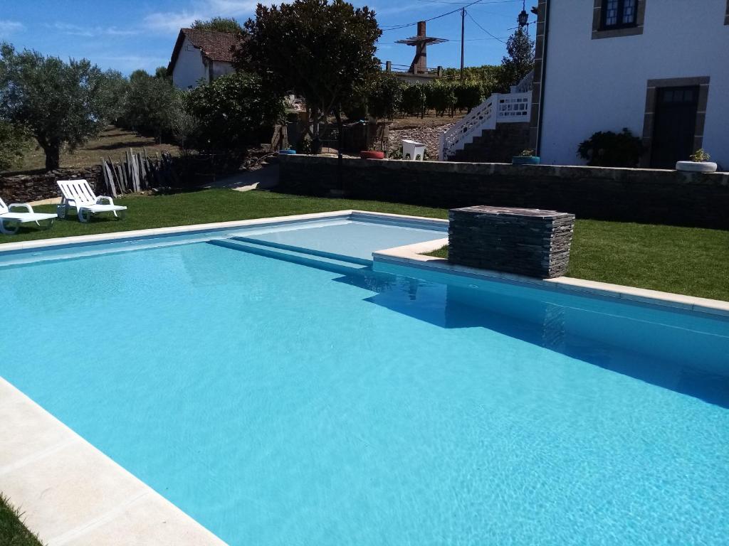 萨布罗萨Solar dos Avós的一座大蓝色游泳池,位于房子前
