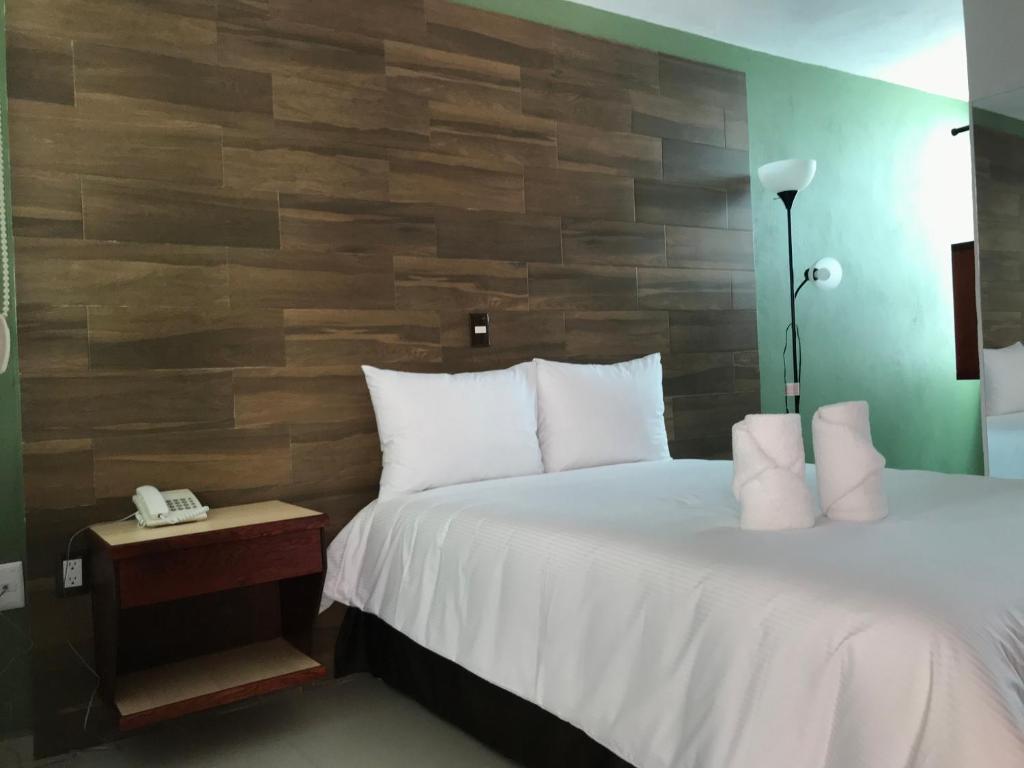 ApizacoMalinalli Express的一间卧室设有一张床和木墙