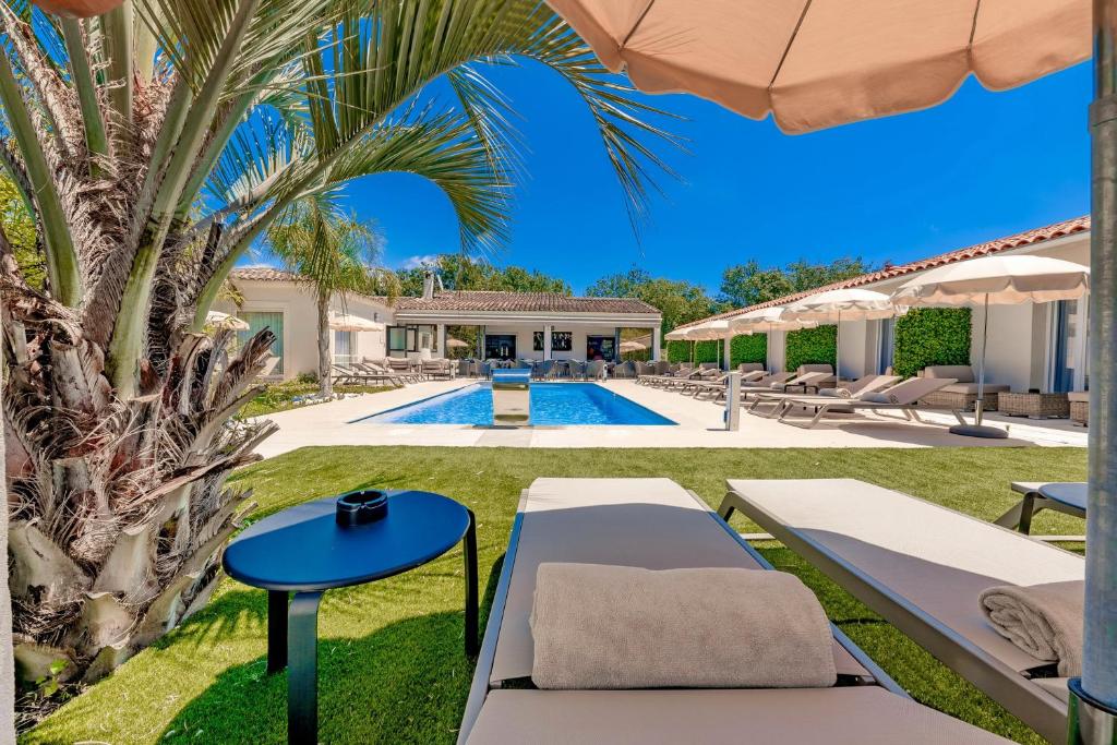 穆然Hôtel Villa Sophia - ADULTS ONLY JULY AND AUGUST的一个带游泳池和棕榈树的别墅