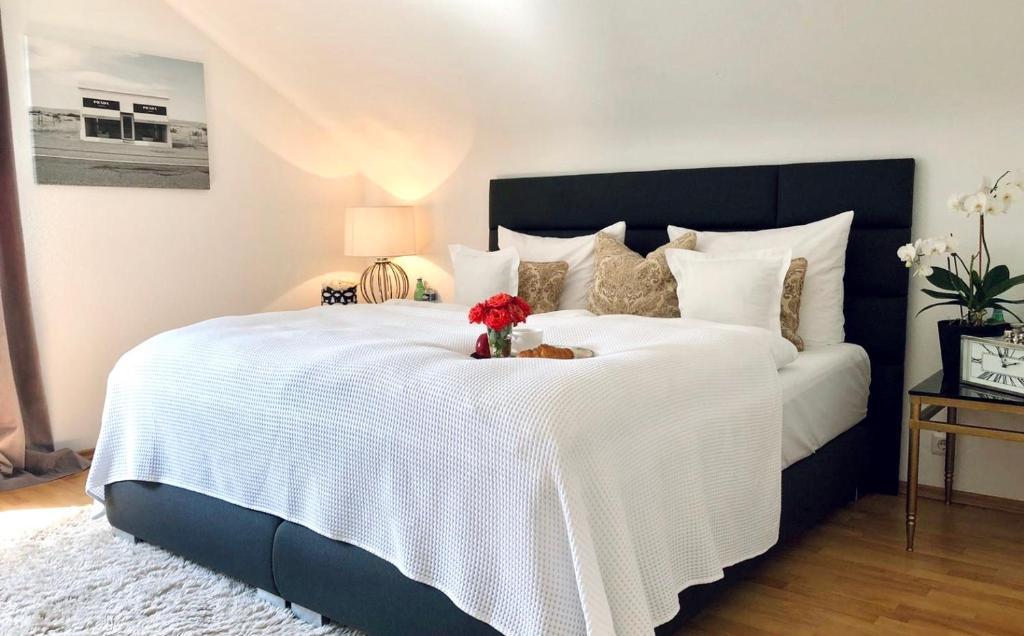 巴登-巴登RS Apartment Baden-Baden的一间卧室配有一张白色大床,床上有鲜花