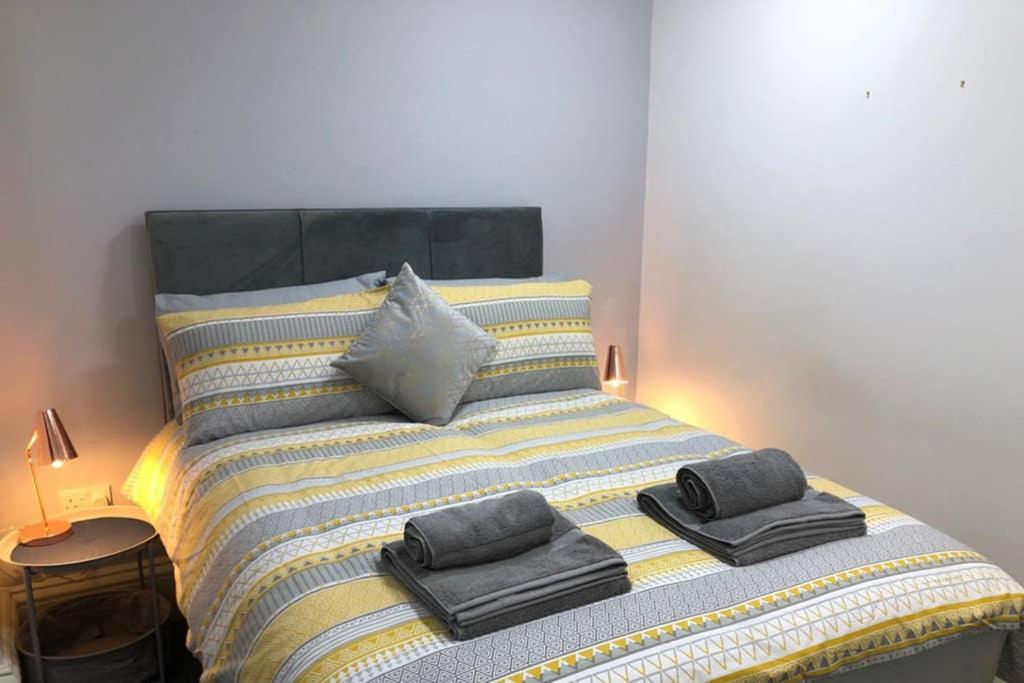 普雷斯顿Fishergate ApartHotel 1 - Stylish City Centre Apartment的床上配有毛巾和枕头