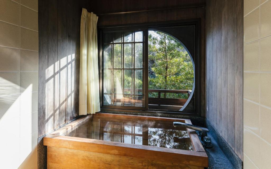 筑紫野市大丸旅馆的带浴缸和窗户的浴室