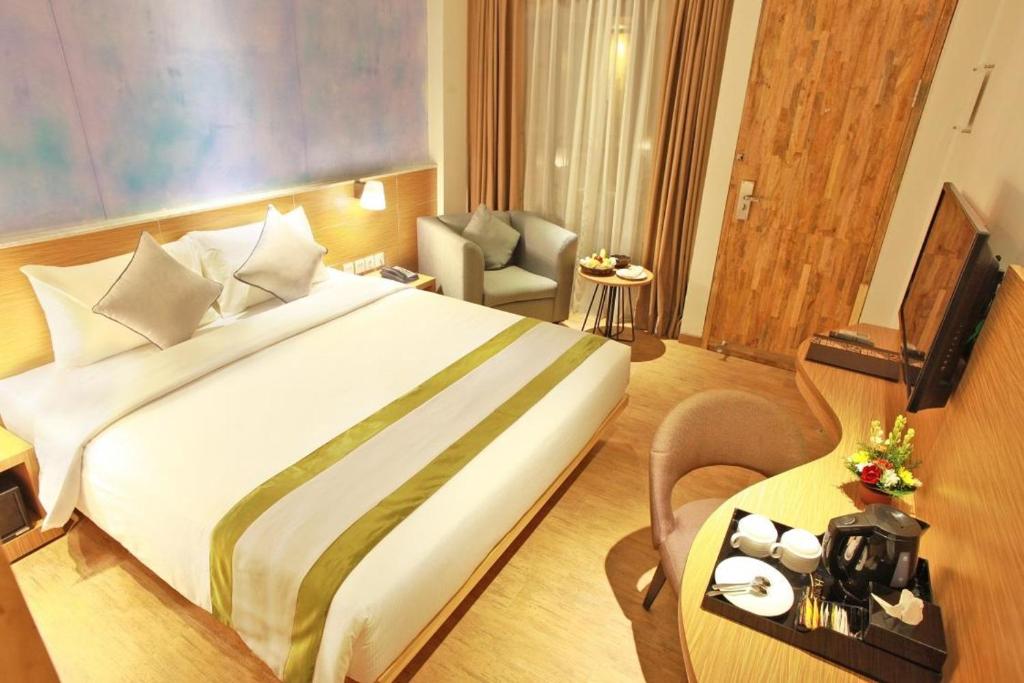 金巴兰Liberta Hotel Jimbaran的酒店客房设有一张大床和一张桌子。