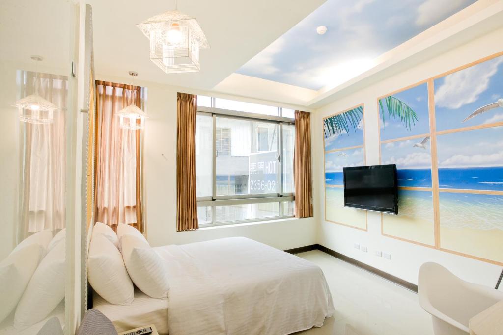 台北东门旅店的一间卧室设有一张床、一台电视和窗户。