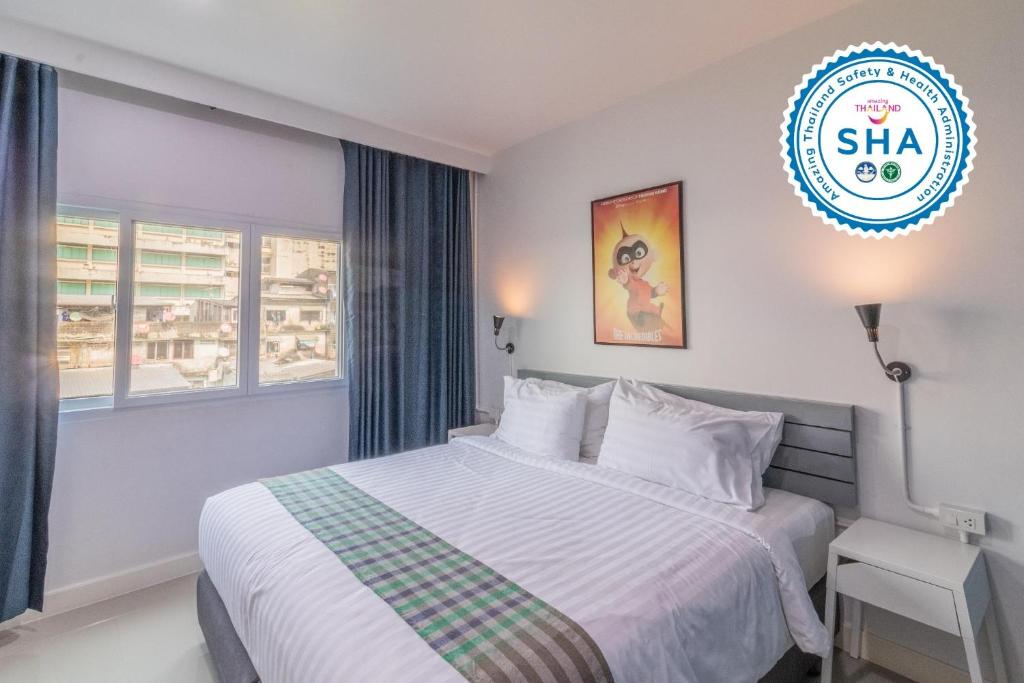 曼谷Every Surawong的卧室配有白色的床和窗户。