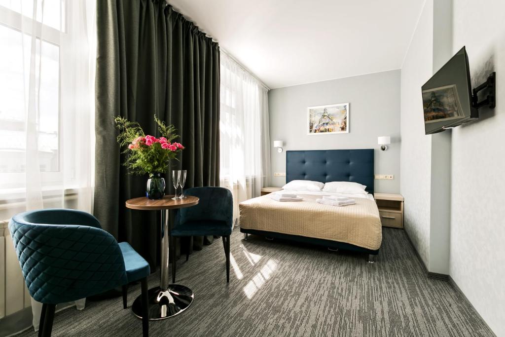 莫斯科Pyatnitskaya Hotel的酒店客房带一张床、一张桌子和椅子