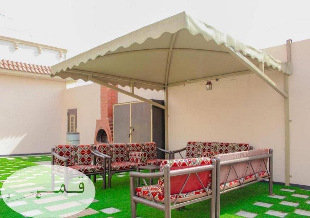 塔伊夫Shams W Qamar Chalets的露台设有椅子和天篷下的桌子