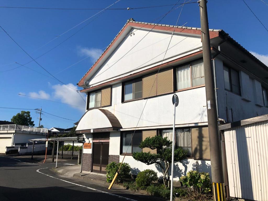 指宿市ゲストハウスまちかど Guest House MACHIKADO的街道拐角处的建筑物