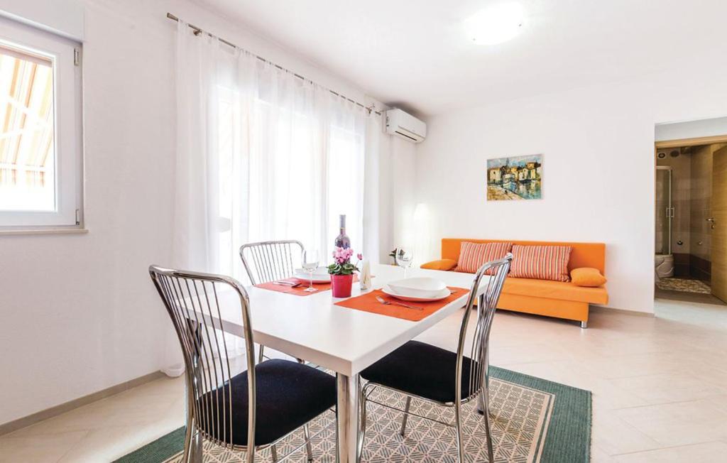 塞尔瑟Apartment VESNA的一间配备有白色桌椅的用餐室