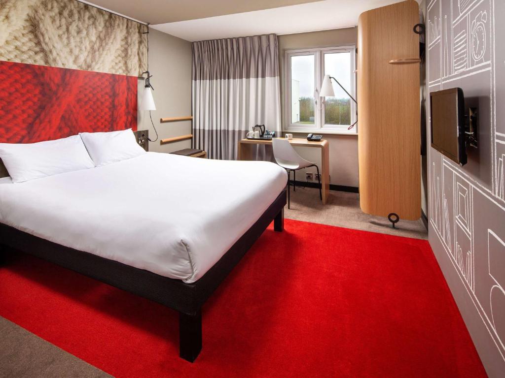 克里克宜必思东拉格比酒店的酒店客房配有一张大床和红地毯。