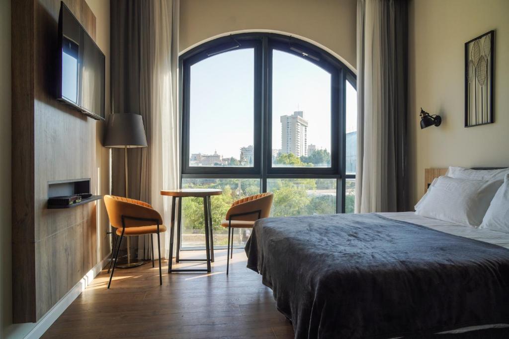 耶路撒冷Apartique Hotel的酒店客房设有一张床和一个大窗户