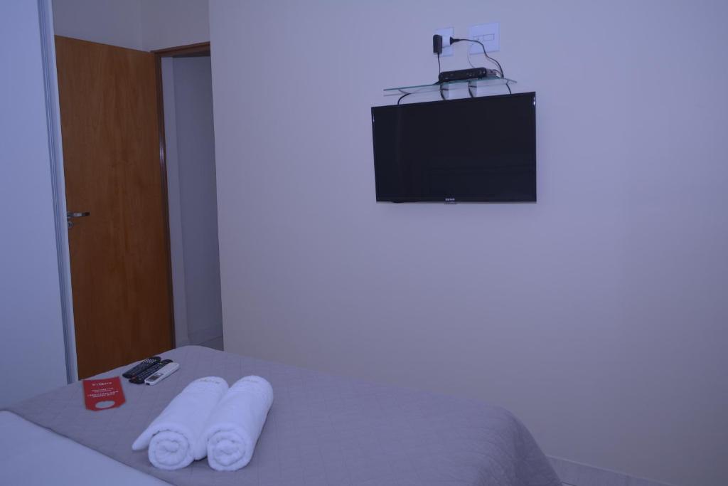 塞蒂拉瓜斯Rivello Apart Hotel的客房设有一张配有电视的床和两条毛巾。