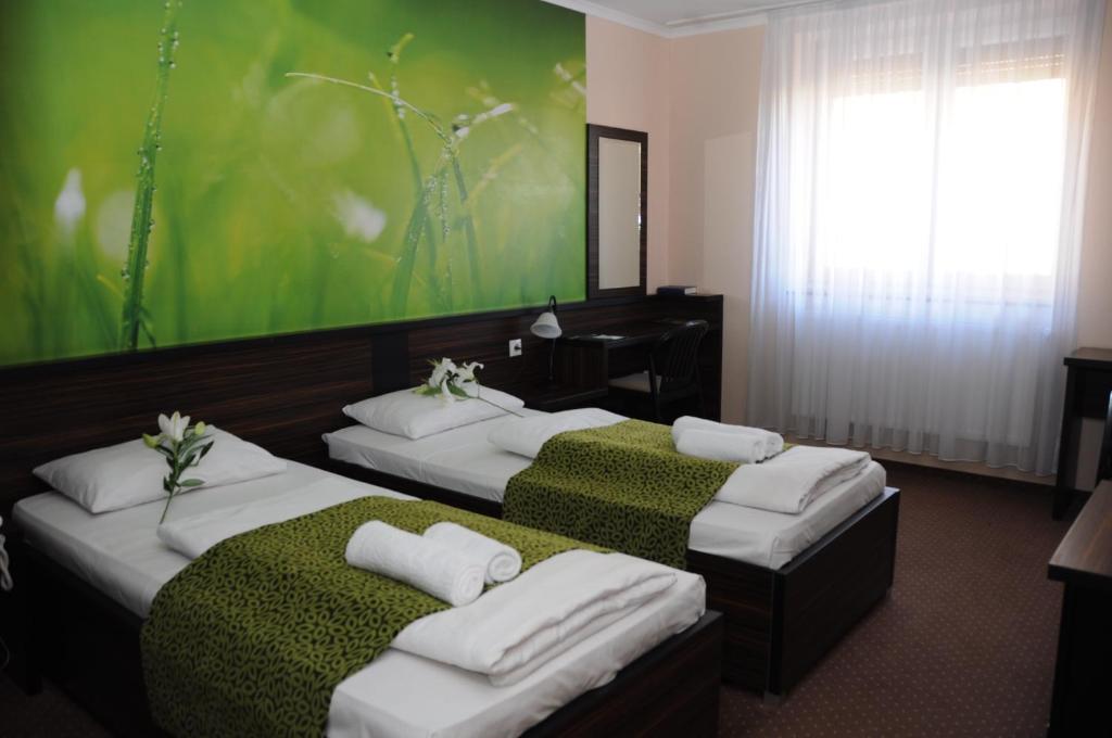 布达佩斯布达佩斯格林酒店的绿墙旅馆客房的两张床