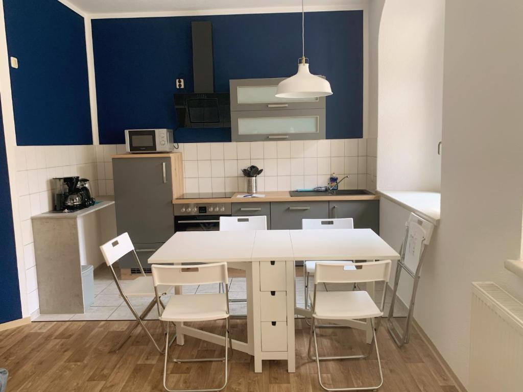 安娜贝格-布赫霍尔茨Ferienwohnung Klosterstrasse mit 2 Schlafzimmern的厨房配有白色的桌椅