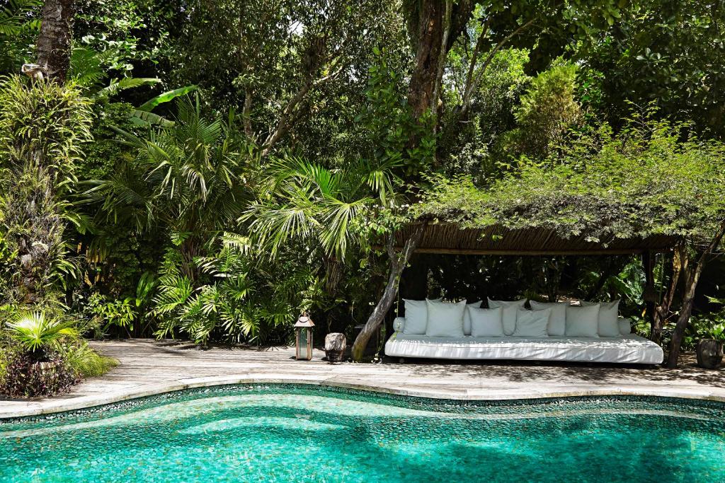 托兰克索UXUA卡萨酒店及Spa的游泳池旁凉亭下的一张床