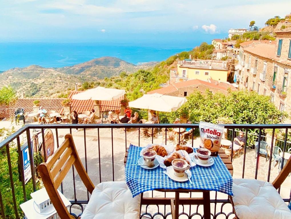 波利卡Sdraiati Apartments - Bed & Breakfast - Pollica的阳台上的桌子上放着咖啡和糕点