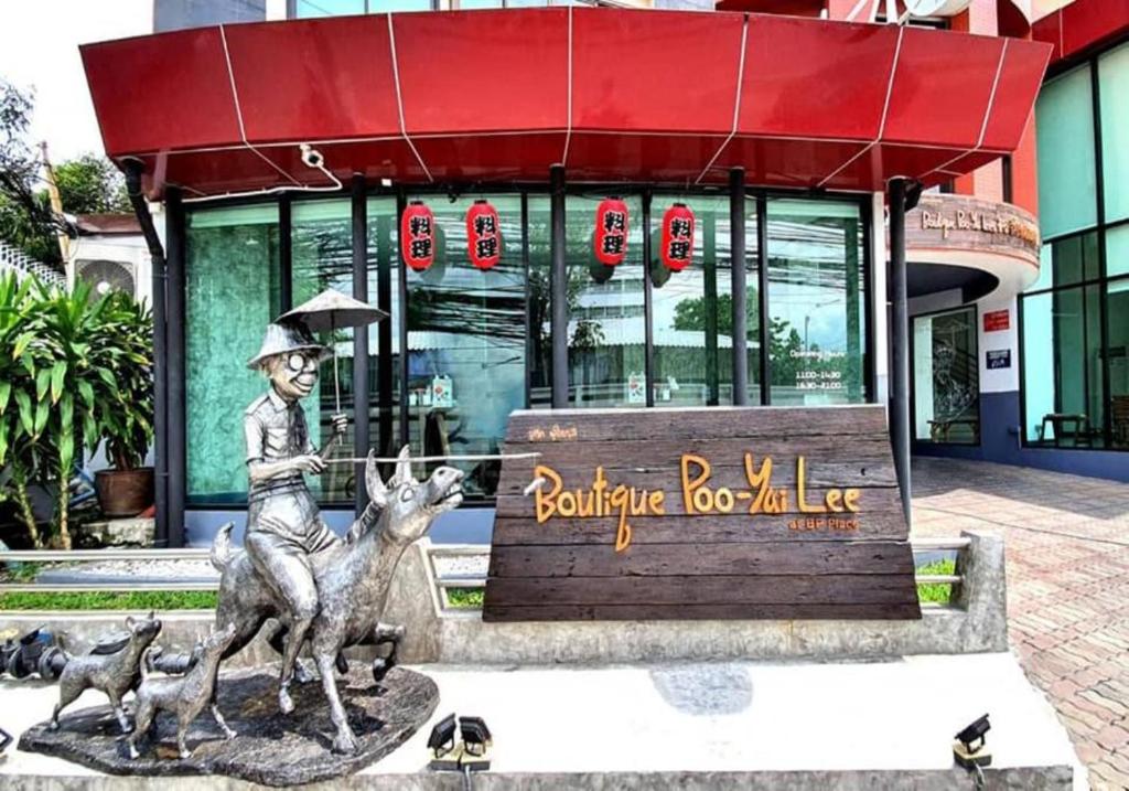 曼谷Boutique Poo-Yai Lee的一座建筑物前骑着鹿的男孩雕像