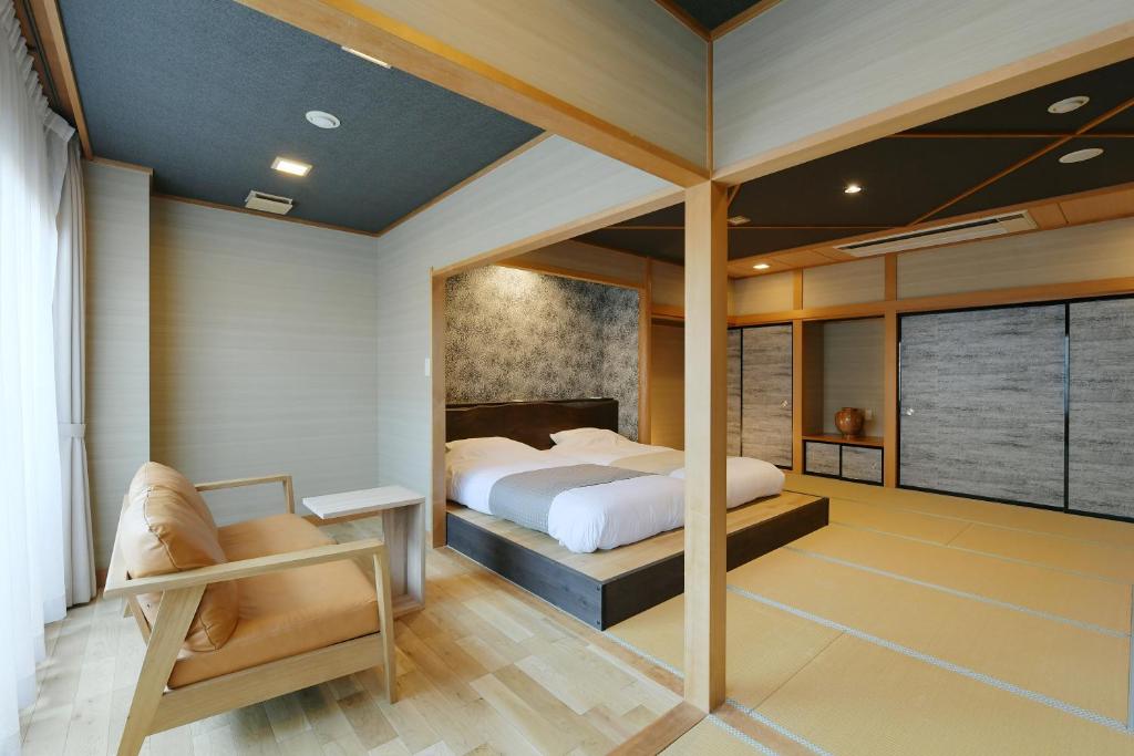 笛吹市花水晶日式旅馆的一间卧室配有一张床和一把椅子