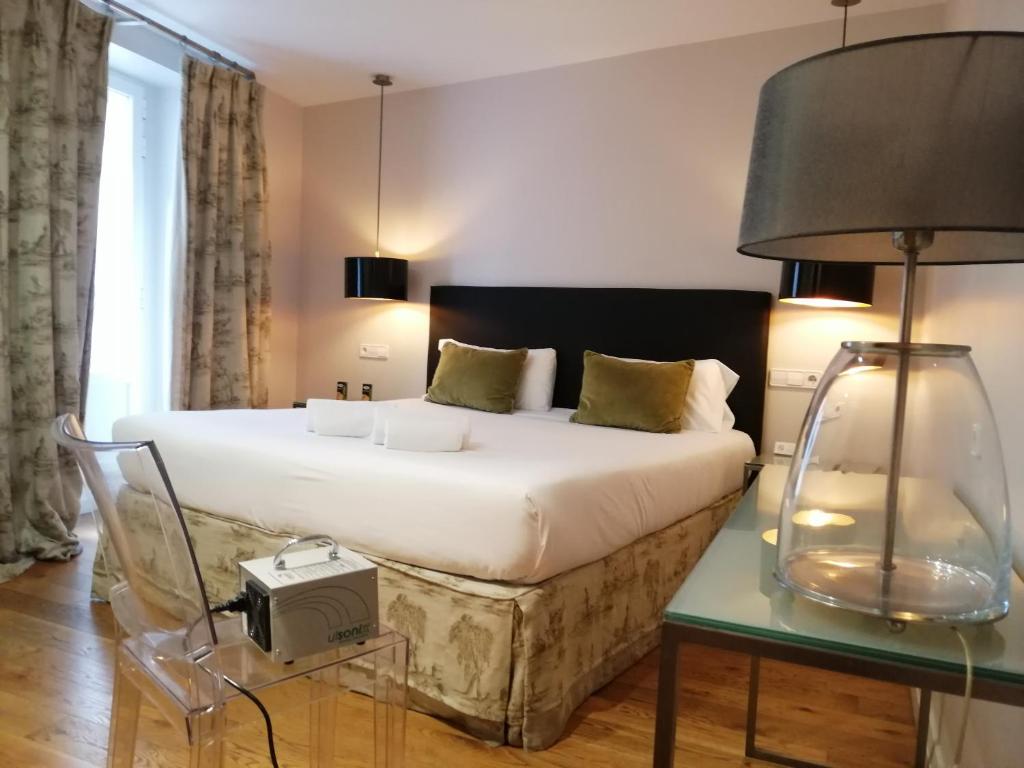 布尔戈斯奎塔米拉普埃布拉酒店的一间卧室配有一张床和一张带台灯的桌子