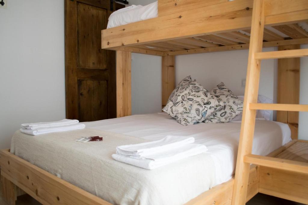 洛雷多Latas Surf Lodge的双层床的上铺是白色毛巾